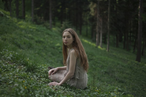 Serious Caucasian woman sitting on hill