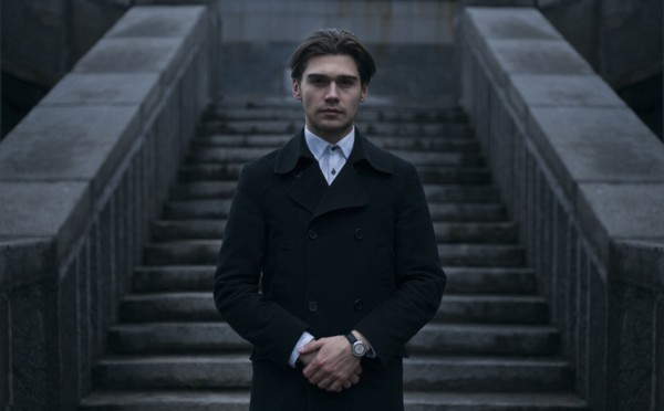 Portrait of serious Caucasian man standing near staircase