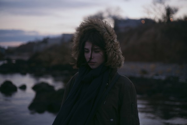 Caucasian woman wearing fur hood at ocean
