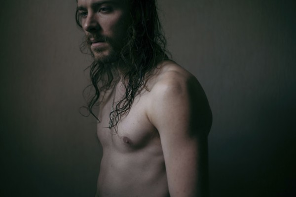 Pensive Caucasian man with long hair and bare chest