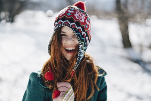 Caucasian woman playing with hat in winter