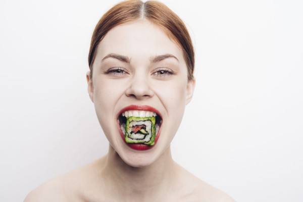 Caucasian woman with mouthful of sushi