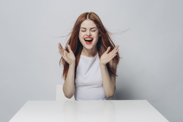 Excited Caucasian woman sitting at windy table