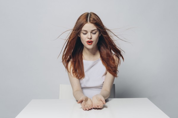 Hopeful Caucasian woman sitting at windy table