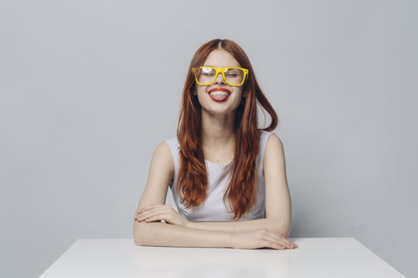 Caucasian woman sitting at table with tongue out