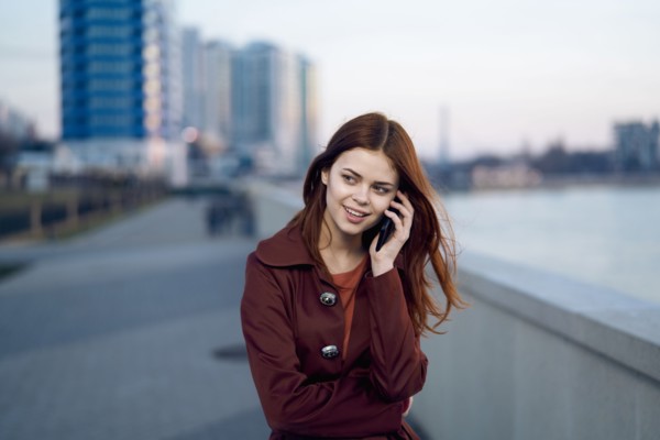 Caucasian woman talking on cell phone at waterfront