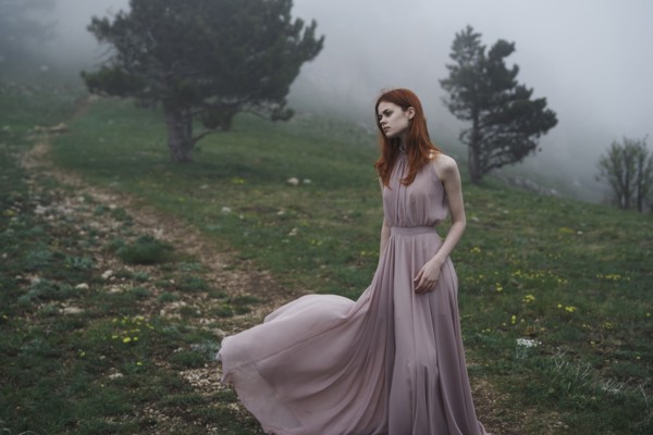 Caucasian woman wearing a dress in field