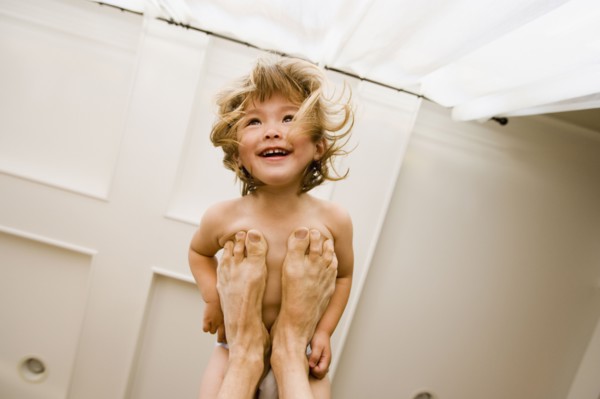Portrait of girl balanced on father's feet