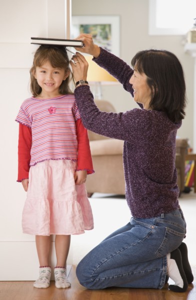 Mother measuring daughter's height