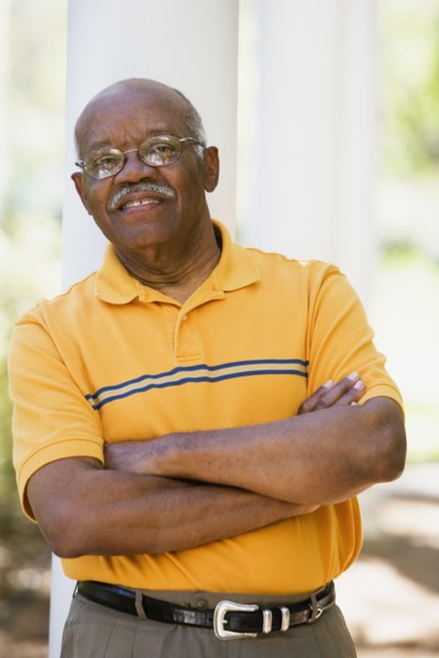 Senior African American man leaning on post outdoors