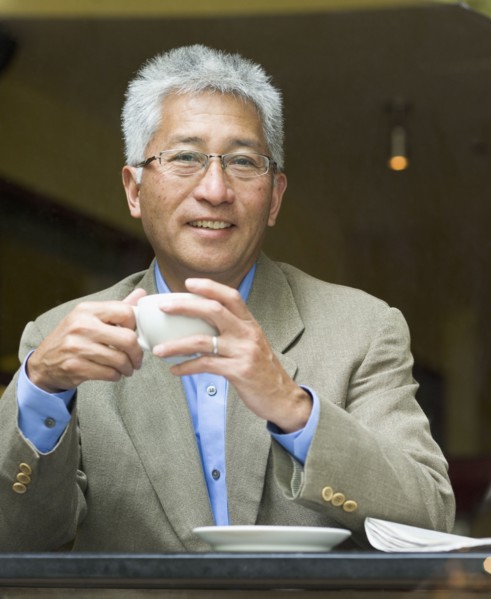 Senior Asian businessman holding cup of coffee
