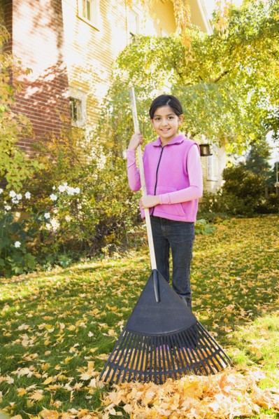Hispanic girl raking leaves