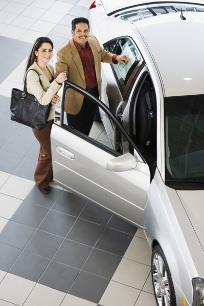 Hispanic couple looking at new car