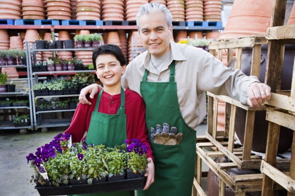 Hispanic father and son working at garden center