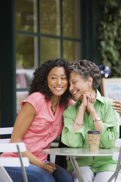 African American mother and adult daughter hugging