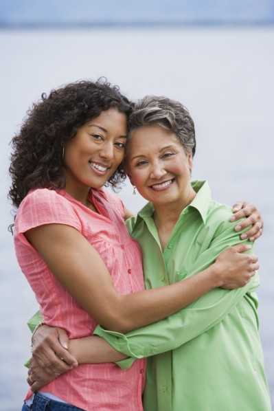 African American mother and adult daughter hugging