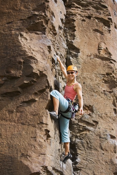 Asian woman rock climbing