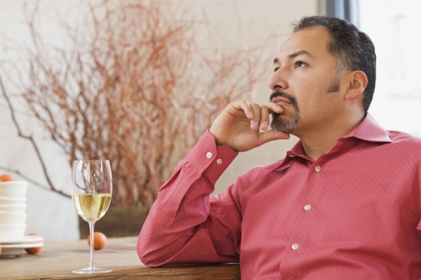 Hispanic man next to glass of wine