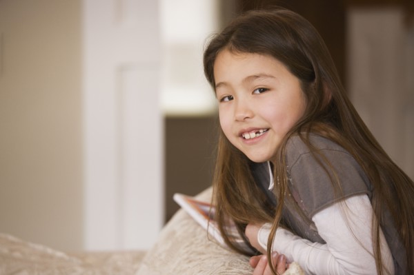 Mixed race girl smiling on sofa