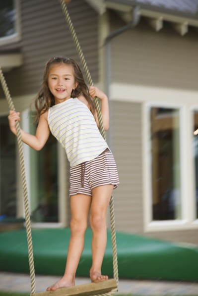 Asian girl swinging on rope swing