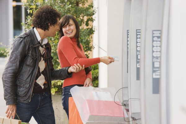 Couple with shopping bags at ATM