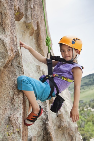 Mixed race girl rock climbing