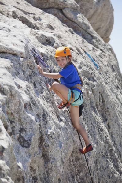 Mixed race girl rock climbing