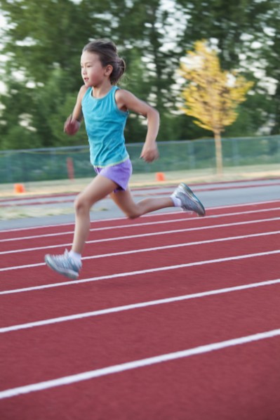 Mixed race girl running on track
