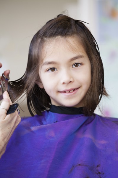 Mixed race girl getting her hair cut