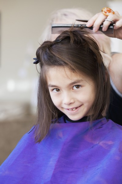 Mixed race girl getting her hair cut