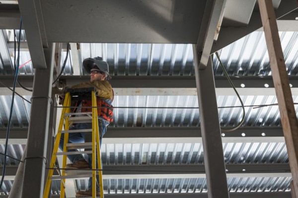 Caucasian construction worker standing on ladder