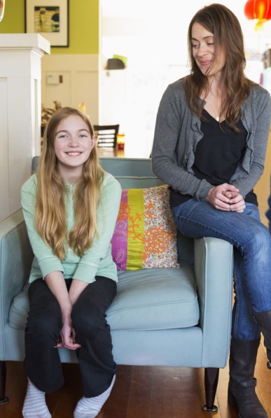 Caucasian mother and daughter smiling in living room
