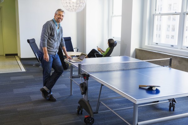 Businessman standing at table tennis table in office