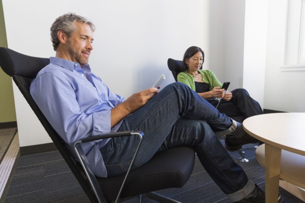 Business people using cell phones in office