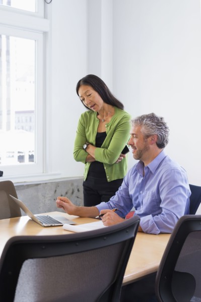 Business people working on laptop in conference room