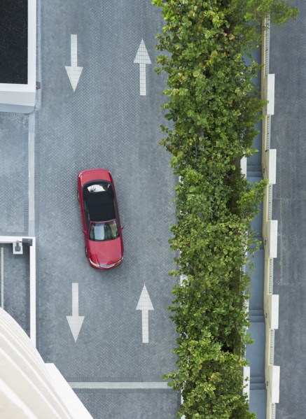 Aerial view of car driving on street with arrows