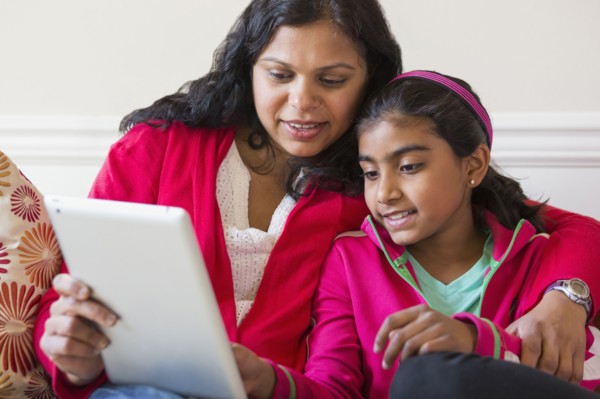 Indian mother and daughter using digital tablet