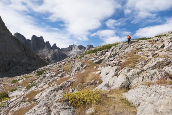 Caucasian hiker walking on rocky hillside