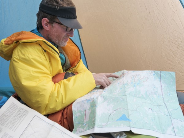 Caucasian man reading map in camping tent