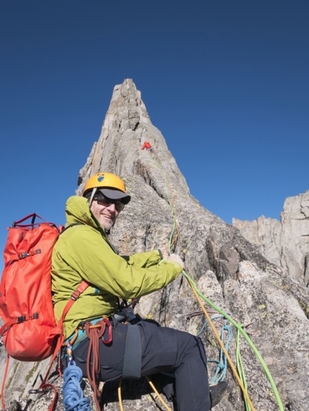 Caucasian climber smiling on mountainside
