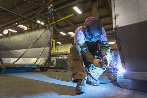 Caucasian man welding metal in factory