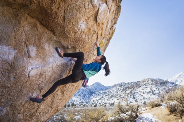 Mixed Race girl climbing rock