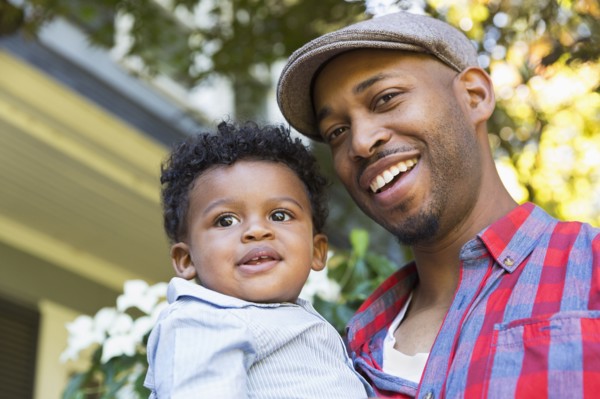 Smiling mixed race father holding baby son