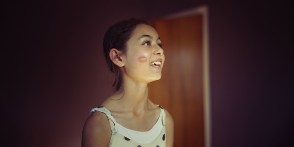 Mixed race girl with lipstick kiss on cheek