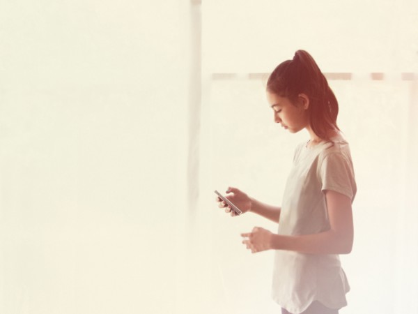 Mixed race girl using cell phone