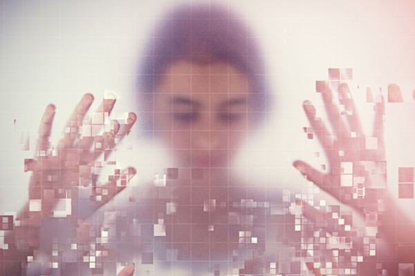 Mixed race girl standing behind pixelated screen