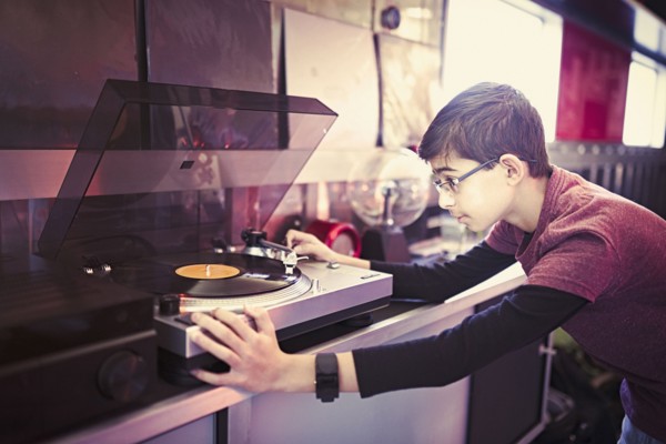 Mixed Race boy playing vinyl record on turntable