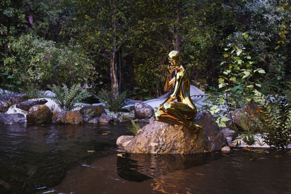 Pensive woman robot sitting on rock at river