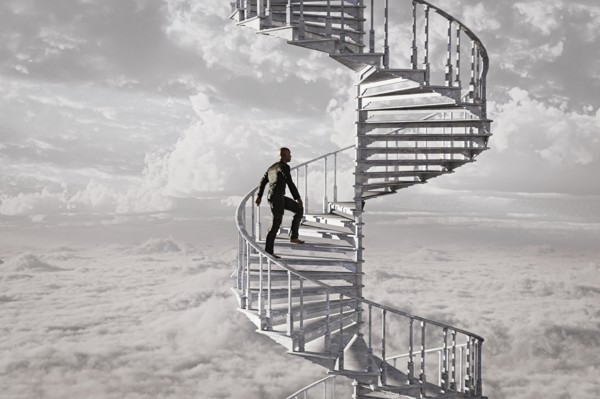 Man climbing spiral staircase in the clouds