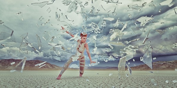 Shards of glass surrounding futuristic woman in desert